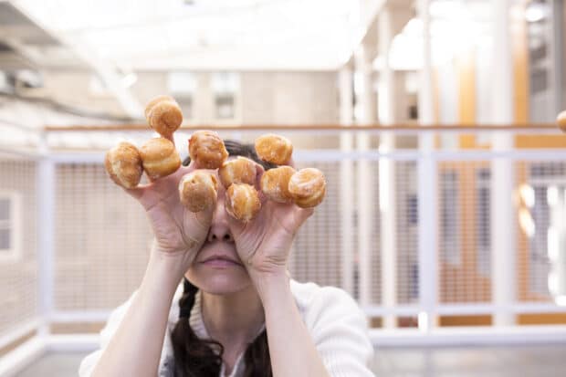 person holding mini doughnuts on each finger