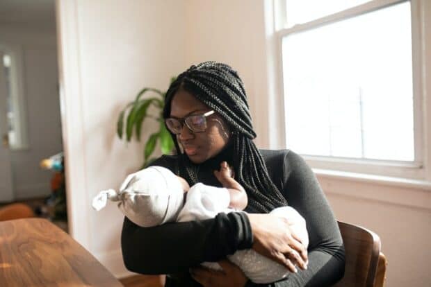 Black woman holding newborn baby