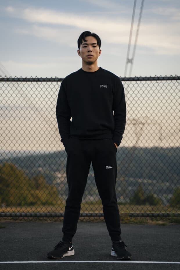 Hafu Guo standing in front of fence